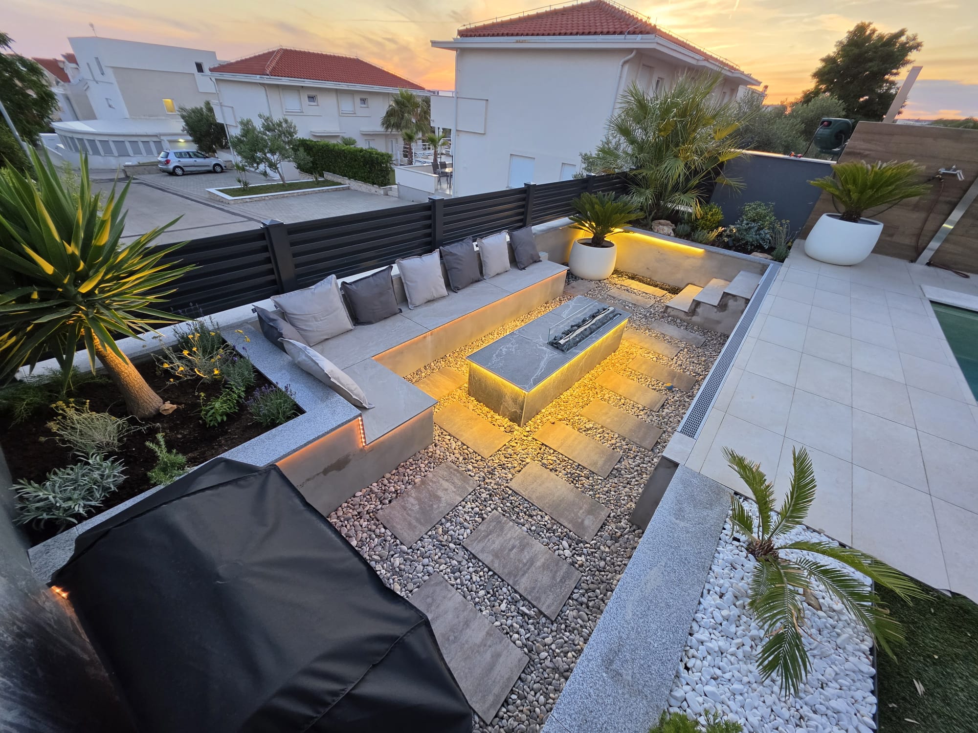Sunken fire pit lounge surrounded by Mediterranean garden at Olea Pool Residence in Novalja, Pag